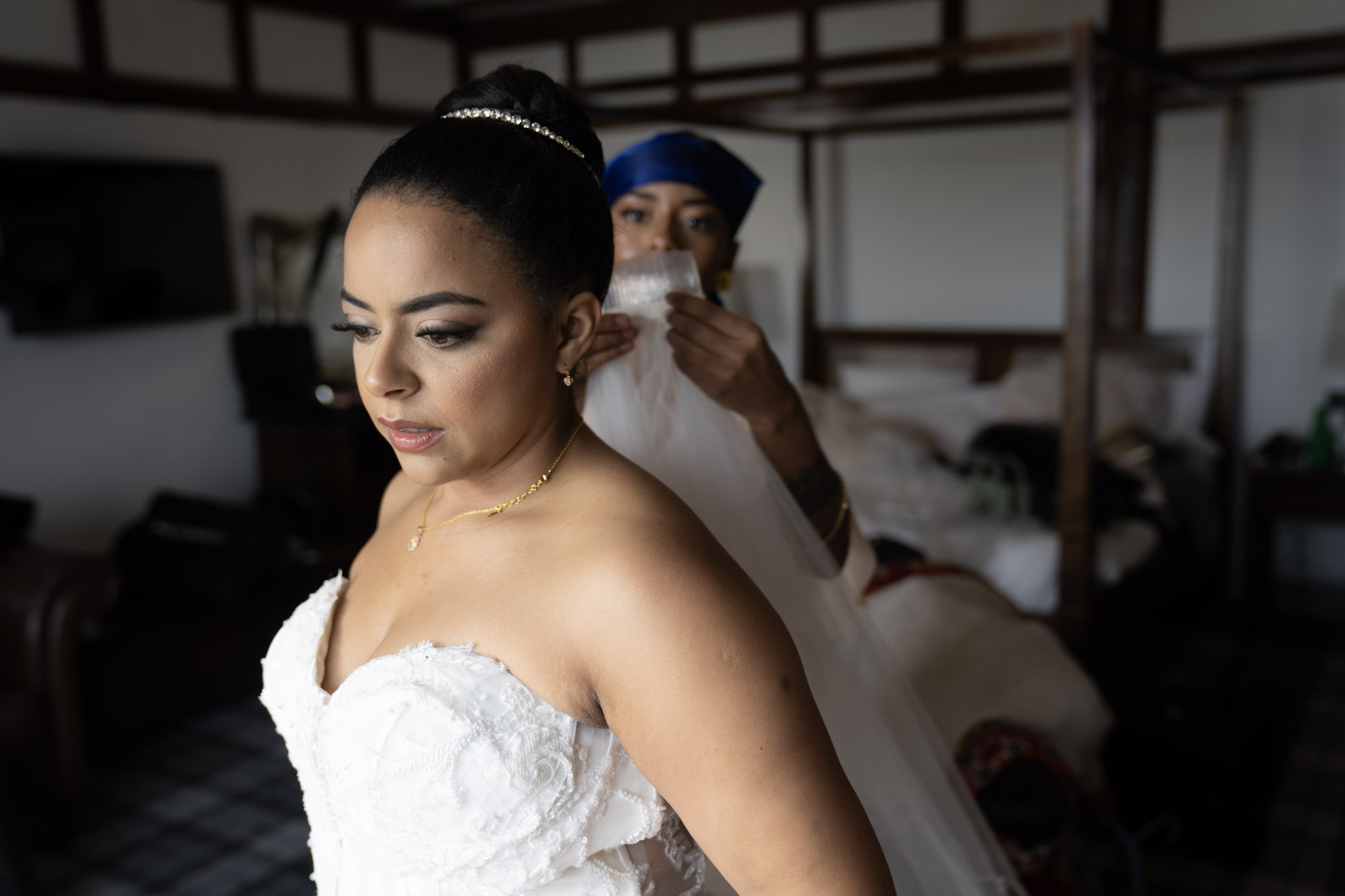 A bride having her veil arranged before the ceremony